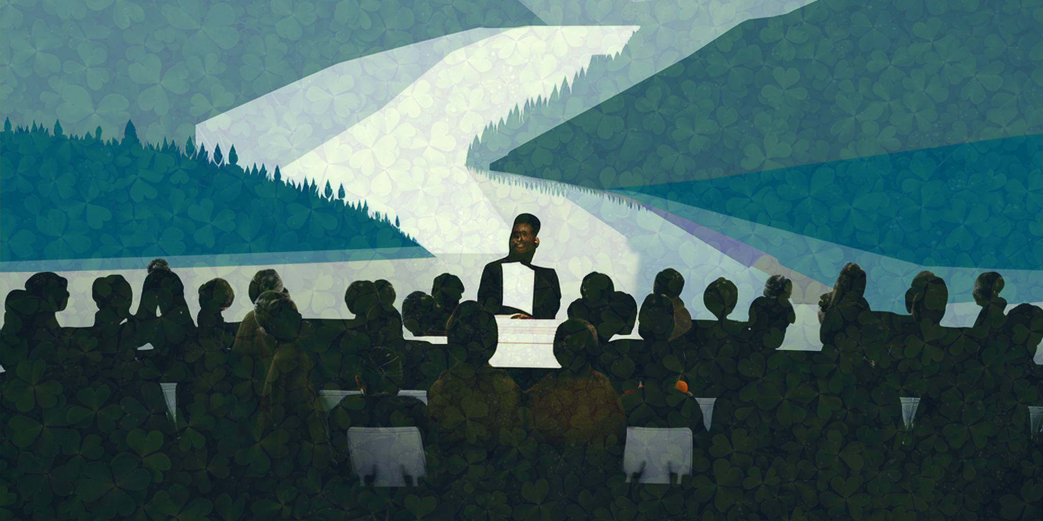 A person speaks to a crowd of people in front of a mural depicting mountains and trees.